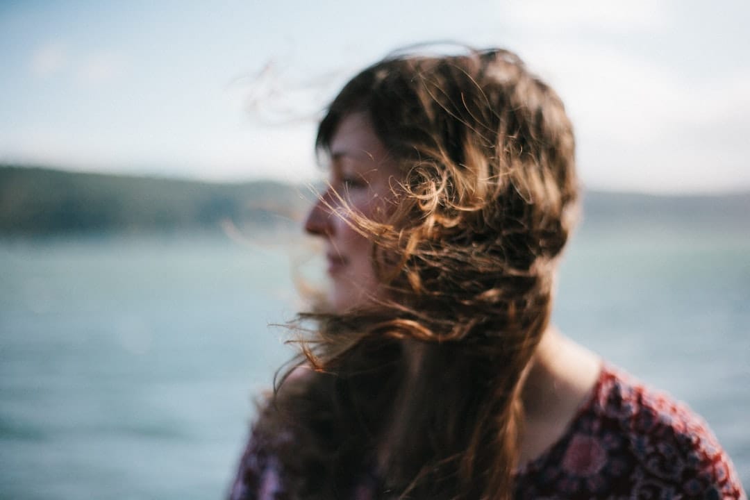 Woman with windblown hair by the water